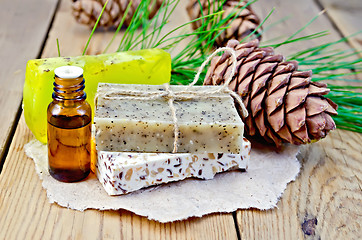 Image showing Oil and soap different cedar cones on board