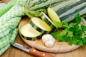 Image showing Zucchini green striped with garlic on a board