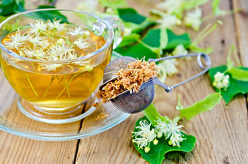 Image showing Herbal tea from linden flowers with strainer on board