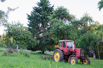 Image showing rustic farm tractor in summer garden 