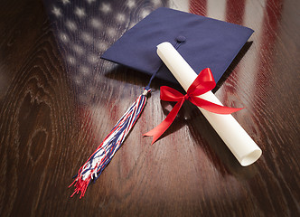 Image showing Graduation Cap and Dipoma on Table with American Flag Reflection