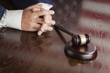 Image showing Judge Rests Hands Behind Gavel with American Flag Table Reflecti