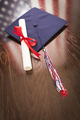 Image showing Graduation Cap and Dipoma on Table with American Flag Reflection