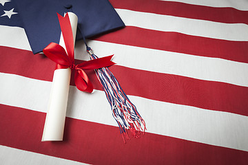 Image showing Graduation Cap and Diploma Resting on American Flag