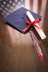 Image showing Graduation Cap and Dipoma on Table with American Flag Reflection