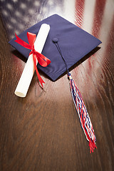 Image showing Graduation Cap and Dipoma on Table with American Flag Reflection