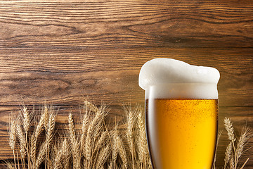 Image showing Glass of beer with wheat on wood