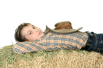 Image showing Country boy resting on hay