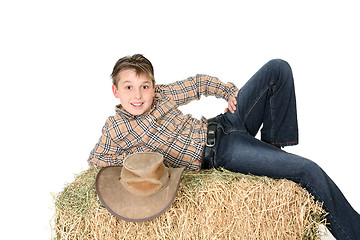 Image showing Rural child lying on hay bale
