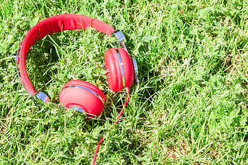 Image showing Vibrant red headphones on fresh glade