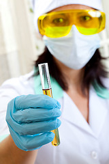 Image showing woman doctor shows a test tube of yellow solution