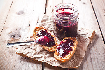 Image showing black currant jam in glass jar and crackers