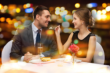 Image showing smiling couple eating dessert at restaurant