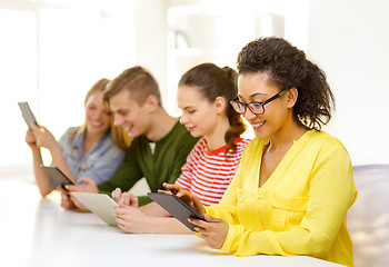 Image showing smiling students looking at tablet pc at school