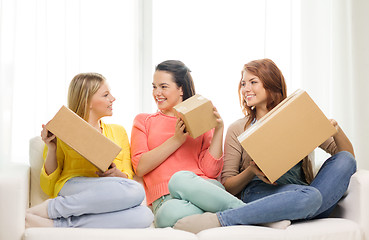 Image showing smiling teenage girls with cardboard boxes at home