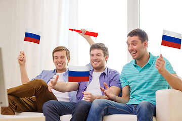 Image showing happy male friends with flags and vuvuzela