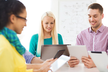 Image showing smiling team with table pc and laptop in office