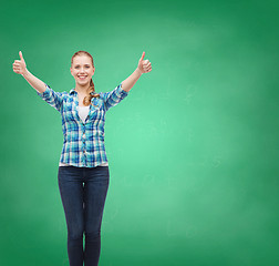 Image showing smiling girl in casual clothes showing thumbs up