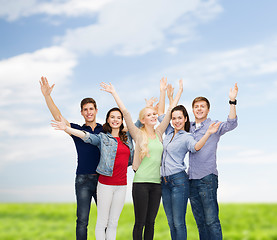 Image showing group of smiling students waving hands