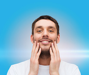 Image showing beautiful smiling man touching his face