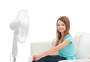 Image showing smiling little girl with big fan at home