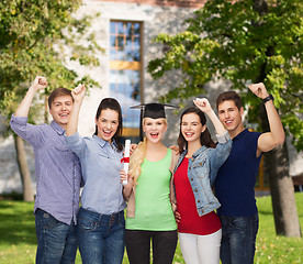 Image showing group of standing smiling students with diploma