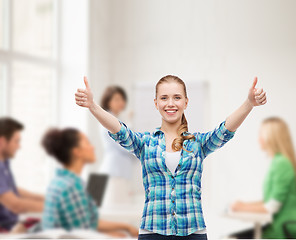 Image showing smiling girl in casual clothes showing thumbs up