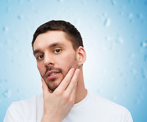 Image showing beautiful calm man touching his face