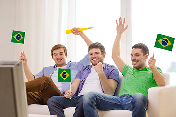 Image showing happy male friends with flags and vuvuzela