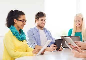 Image showing smiling team with table pc and laptop in office