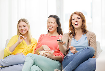 Image showing three smiling teenage girl watching tv at home