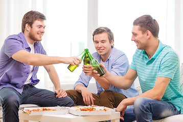 Image showing smiling friends with beer and pizza hanging out