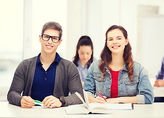 Image showing two teenagers with notebooks and book at school