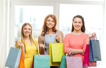 Image showing smiling teenage girls with many shopping bags