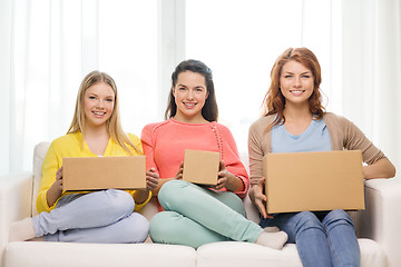 Image showing smiling teenage girls with cardboard boxes at home
