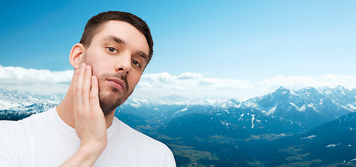 Image showing beautiful calm man touching his face