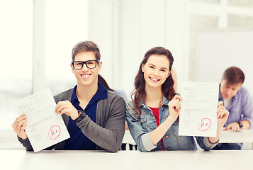 Image showing two teenagers holding test or exam with grade A