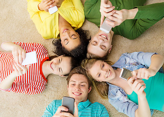 Image showing group of smiling people lying down on floor