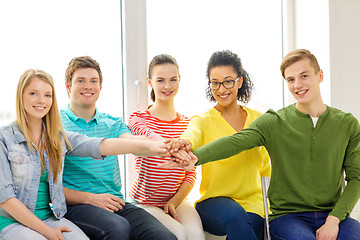 Image showing smiling students with hands on top of each other