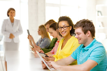 Image showing smiling female students with tablet pc at school