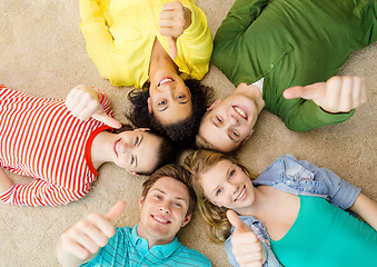 Image showing group of smiling people lying down on floor