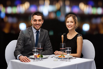 Image showing smiling couple eating main course at restaurant