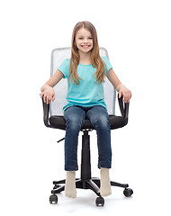 Image showing smiling little girl sitting in big office chair