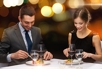 Image showing smiling couple eating main course at restaurant