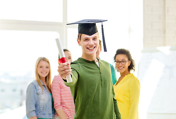 Image showing smiling male student with diploma and corner-cap