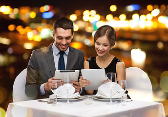 Image showing couple with menus on tablet pc at restaurant