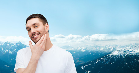 Image showing beautiful smiling man touching his face