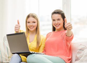 Image showing two smiling teenage girls with laptop at home