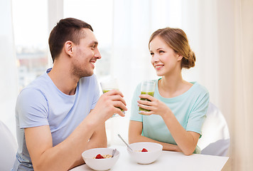 Image showing smiling couple having breakfast at home