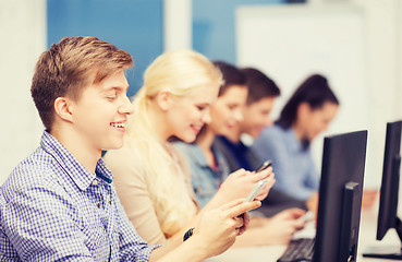 Image showing students with computer monitor and smartphones